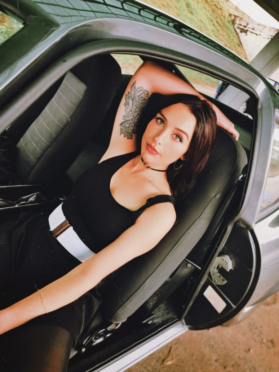 Alexa Barron sitting in the driver's seat of a car with the door open